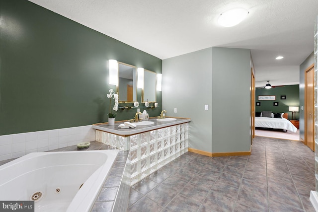 bathroom featuring sink, a relaxing tiled tub, tile patterned floors, and ceiling fan