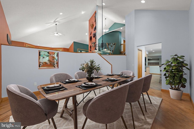 dining area featuring ceiling fan, hardwood / wood-style floors, and high vaulted ceiling