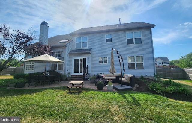 back of house featuring a yard, an outdoor living space, and a patio area