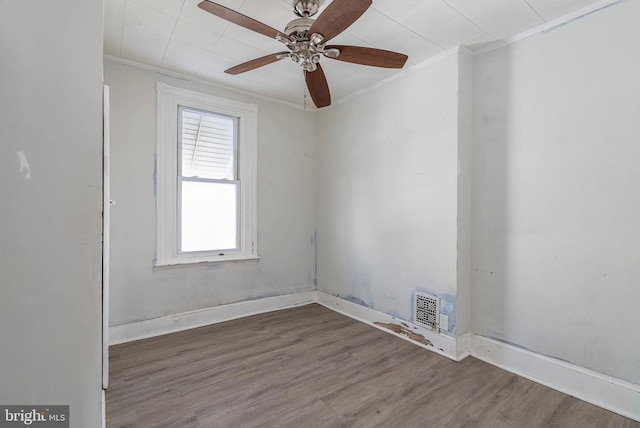 empty room featuring ornamental molding, dark hardwood / wood-style floors, and ceiling fan