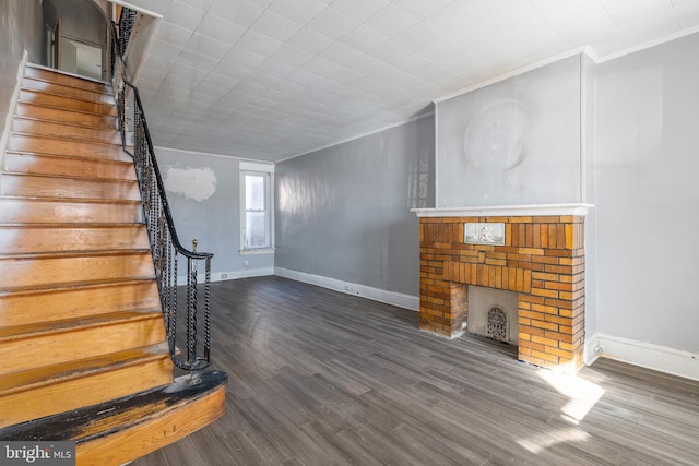 unfurnished living room featuring dark hardwood / wood-style flooring, crown molding, and a fireplace