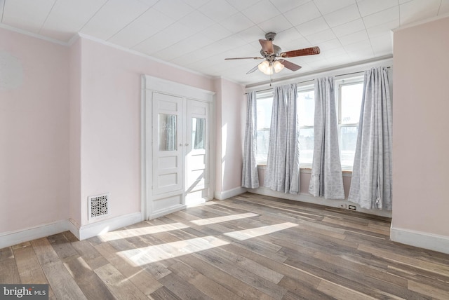 spare room featuring hardwood / wood-style floors, crown molding, and ceiling fan