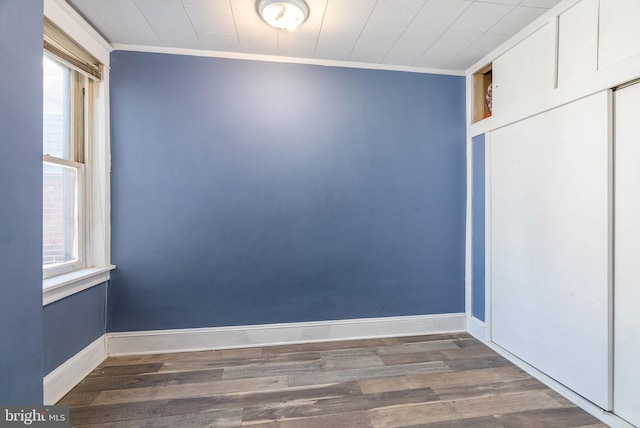 empty room with ornamental molding, dark hardwood / wood-style floors, and a wealth of natural light