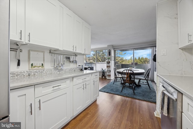 kitchen featuring dishwasher, wood finished floors, and white cabinetry