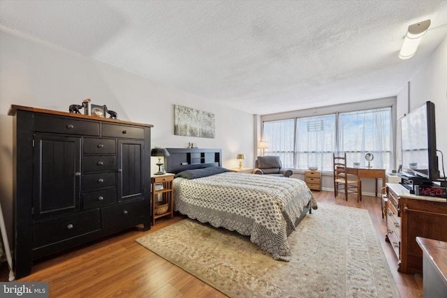 bedroom with wood finished floors and a textured ceiling