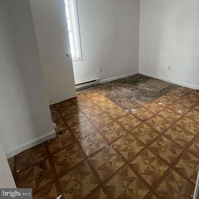 unfurnished room featuring baseboard heating and dark parquet floors