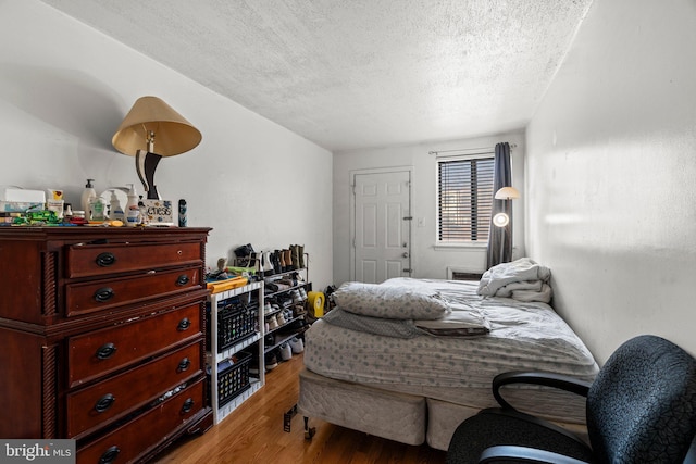 bedroom with hardwood / wood-style flooring and a textured ceiling