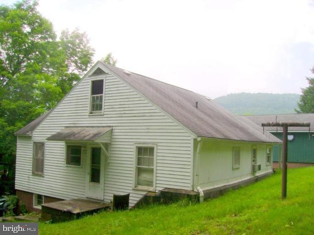 rear view of property with a lawn