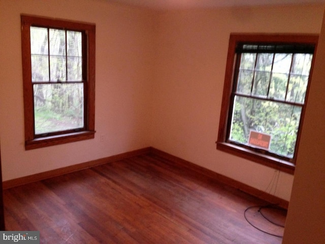 unfurnished room with wood-type flooring