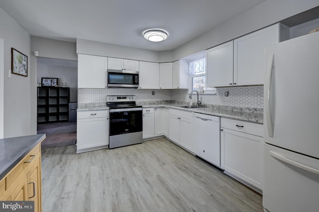 kitchen featuring stainless steel appliances, white cabinetry, sink, and light hardwood / wood-style floors