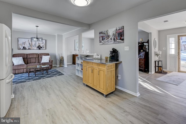 kitchen with light wood-type flooring, light brown cabinets, and white fridge