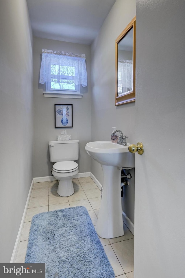 bathroom with sink, toilet, and tile patterned flooring