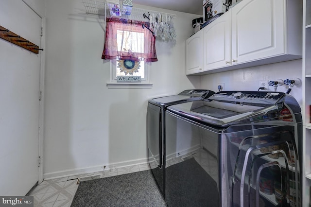 washroom featuring cabinets and independent washer and dryer