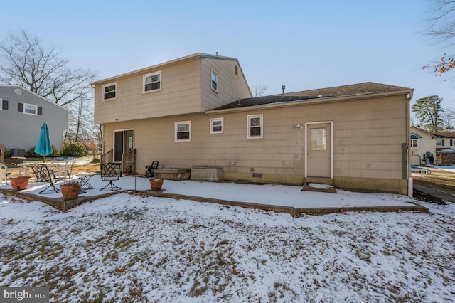 view of snow covered rear of property