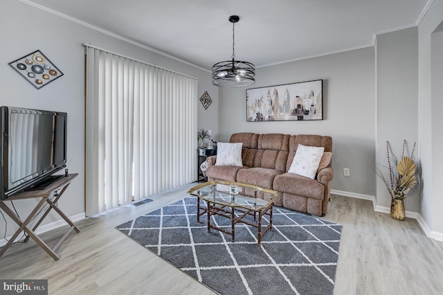 living room featuring ornamental molding, wood-type flooring, and a chandelier