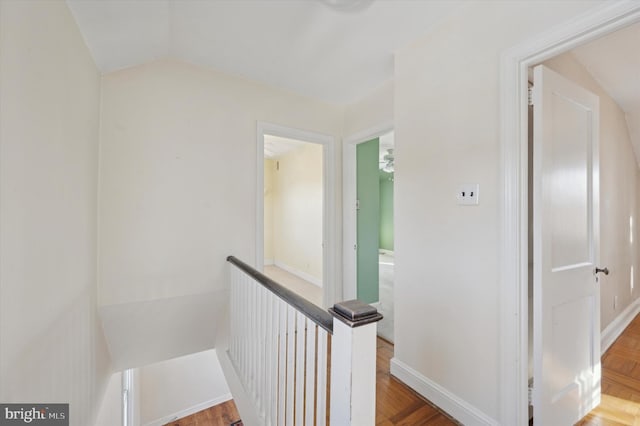 hallway with vaulted ceiling and hardwood / wood-style floors