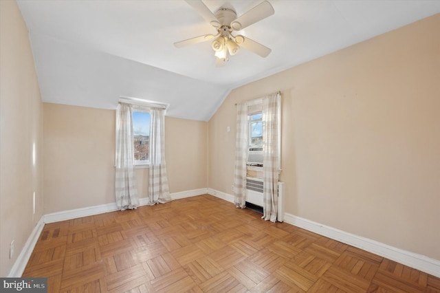 spare room featuring light parquet flooring, vaulted ceiling, a healthy amount of sunlight, and ceiling fan