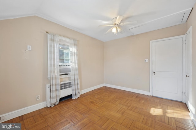 empty room featuring light parquet floors, vaulted ceiling, radiator heating unit, and ceiling fan