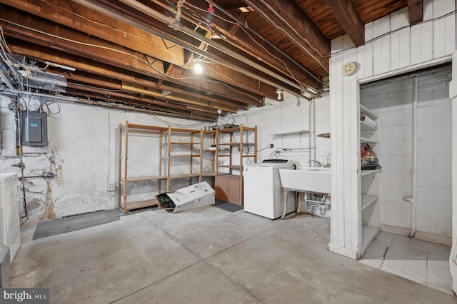 basement with washing machine and clothes dryer, electric panel, and sink