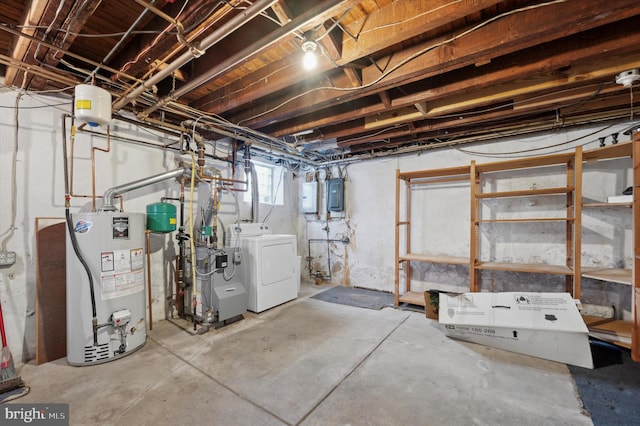 basement featuring water heater, electric panel, and independent washer and dryer