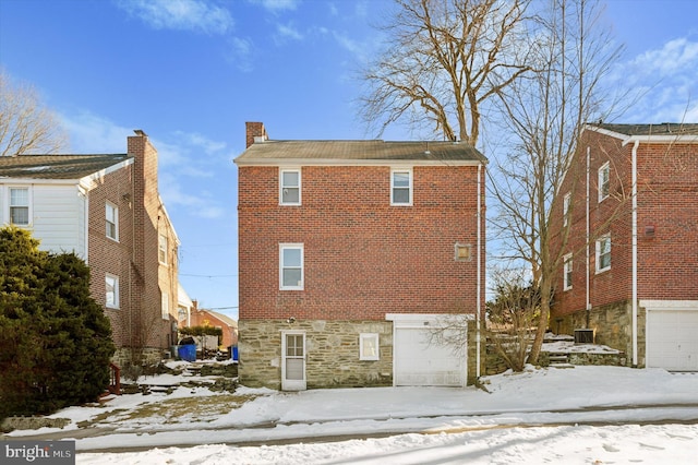 snow covered property featuring a garage