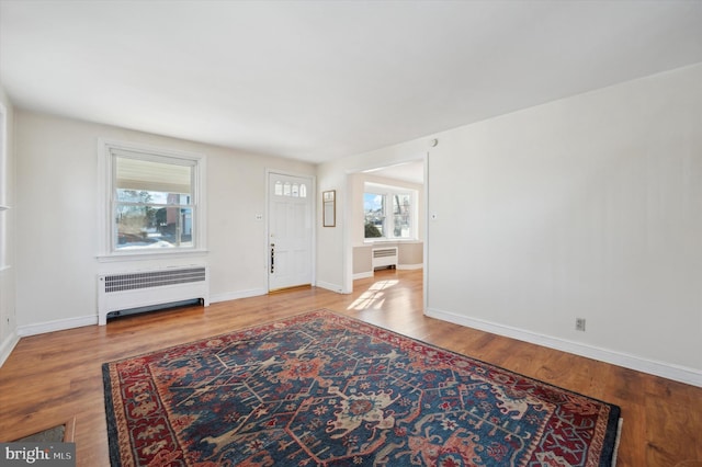 entryway with radiator and hardwood / wood-style floors