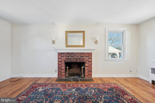 living room with wood-type flooring, a fireplace, and radiator