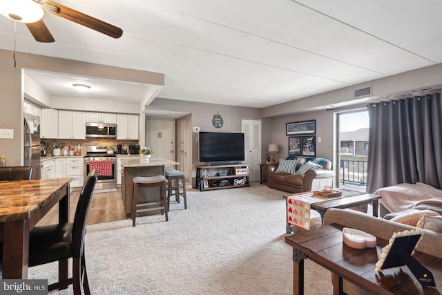 carpeted living room featuring ceiling fan