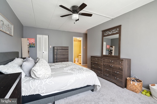 bedroom with ensuite bathroom, carpet, ceiling fan, and a closet