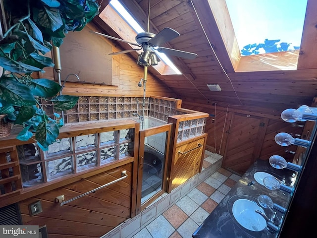 interior details with a skylight, wooden walls, wooden ceiling, and ceiling fan