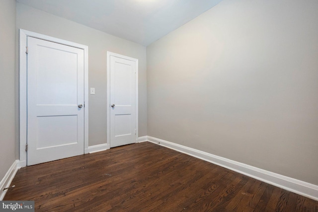 unfurnished bedroom featuring dark wood-style floors and baseboards