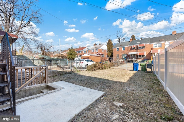 view of yard featuring a residential view, a fenced backyard, and a patio