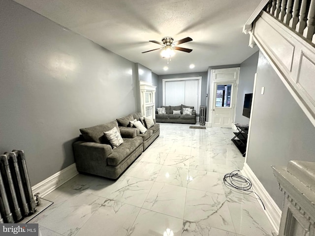 living room with ceiling fan, radiator heating unit, and a textured ceiling