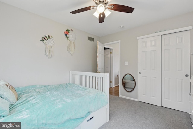 bedroom featuring a closet, light colored carpet, visible vents, a ceiling fan, and baseboards