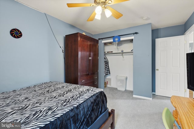 bedroom featuring light carpet, ceiling fan, a closet, and baseboards