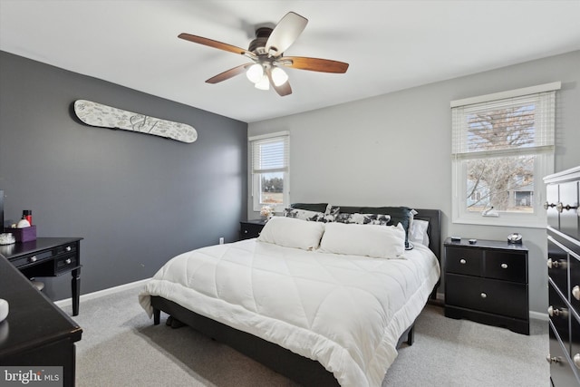 bedroom featuring light carpet, ceiling fan, and baseboards