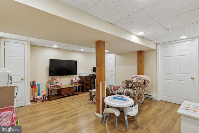 playroom featuring baseboard heating, a drop ceiling, light wood-style flooring, and recessed lighting