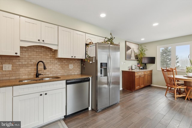 kitchen featuring appliances with stainless steel finishes, white cabinets, and a sink