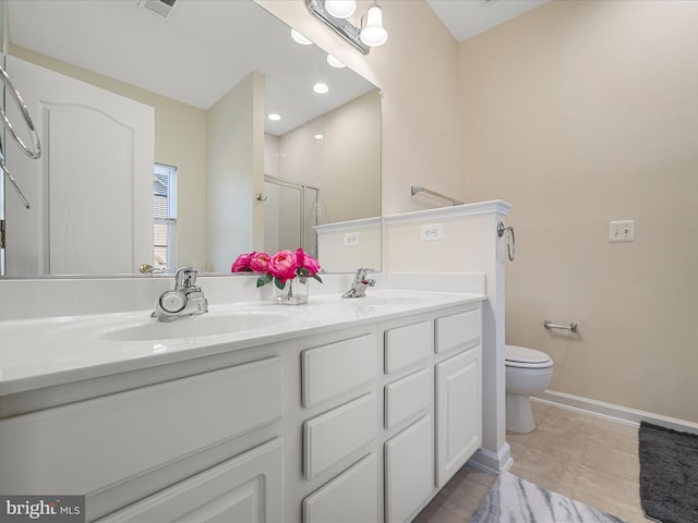 bathroom featuring tile patterned floors, vanity, toilet, and a shower with door