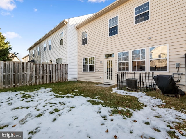 view of snow covered back of property