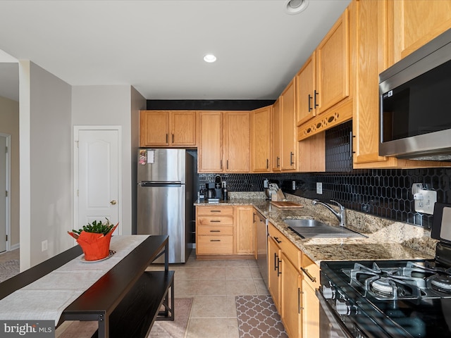 kitchen featuring appliances with stainless steel finishes, sink, light tile patterned floors, light stone countertops, and light brown cabinets