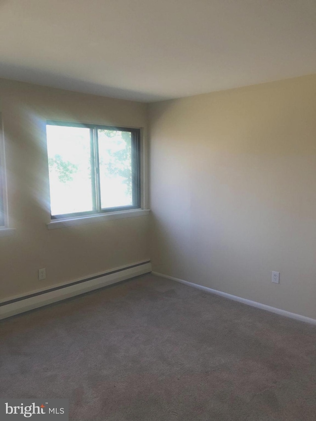 carpeted empty room with baseboard heating