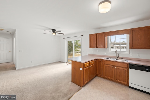 kitchen with sink, light colored carpet, white dishwasher, kitchen peninsula, and ceiling fan