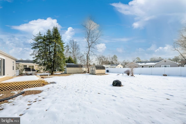 yard layered in snow with a storage unit