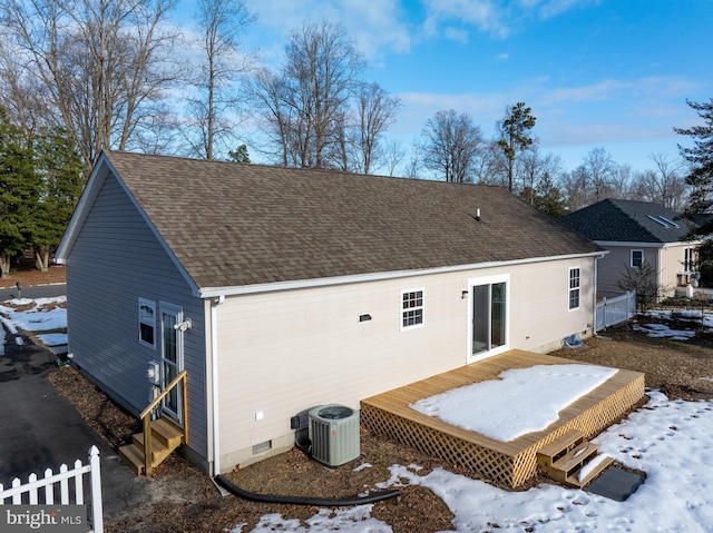 snow covered rear of property featuring a wooden deck and central air condition unit