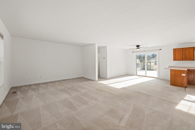 unfurnished living room with light carpet and ceiling fan