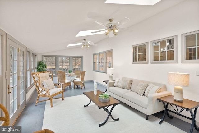 living room with vaulted ceiling with skylight and a ceiling fan