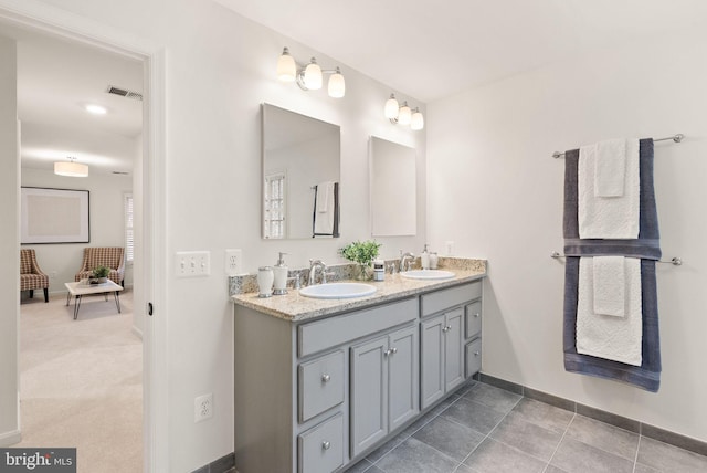 full bathroom featuring visible vents, a sink, baseboards, and double vanity