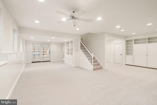 basement featuring light carpet, stairway, built in features, and recessed lighting