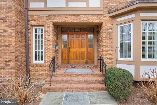 entrance to property featuring brick siding